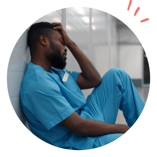 Fortvilet sykepleier sitter på gulvet i gangen