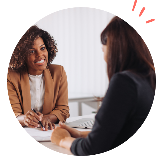 To damer sitter på kontor og har en samtale.