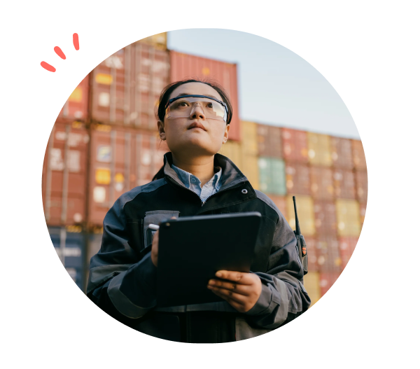 Kvinne med ipad som står foran konteinere