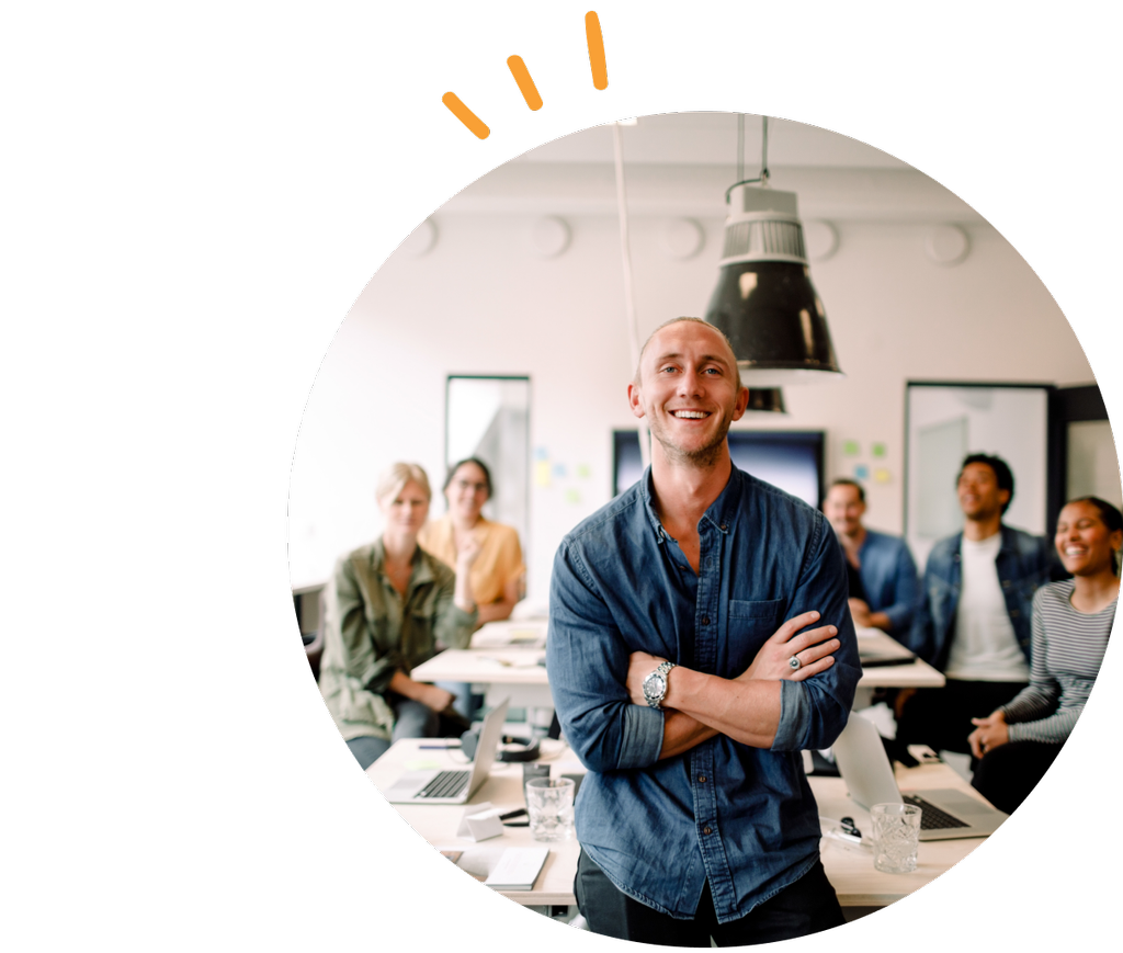 Mann foran et bord med ansatte på et kontor.