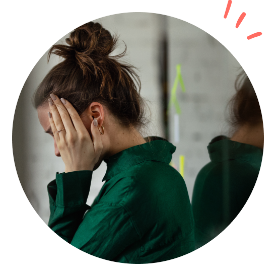 Dame som holder seg til hodet og er tydelig sliten.