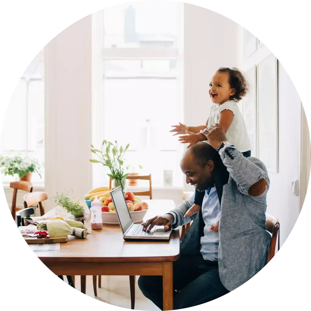 Mann som jobber hjemmefra med en datter på skulderene.